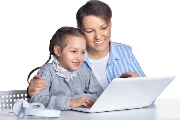 Emocional mãe e filha usando laptop posando contra branco