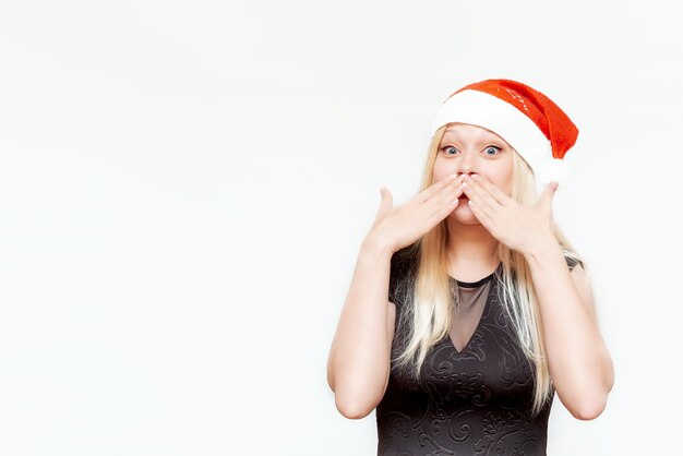 Emocional retrato de una chica rubia con un sombrero de Santa Claus Feliz Navidad