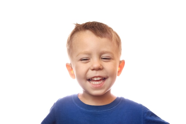 Emociones de un niño feliz sobre un fondo blanco en el estudio