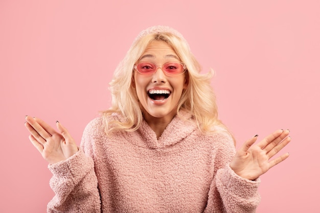 Las emociones positivas emocionaron a la elegante dama gritando de alegría y extendiendo las manos posando sobre rosa