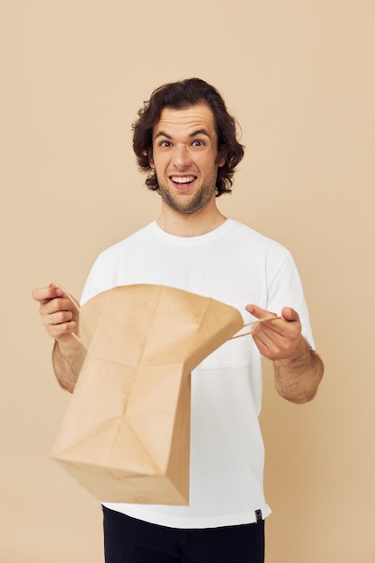 Emoções de saco de papel de homem atraente posando estilo de vida inalterado
