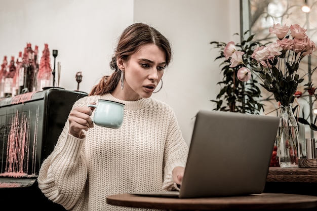 Emoções durante o trabalho. Freelancer é emocional enquanto trabalha em um café com seu computador