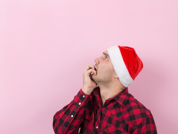 Emoções no rosto, medo, lembranças de férias, negativos. Um homem em um coelho xadrez e um chapéu vermelho de Natal