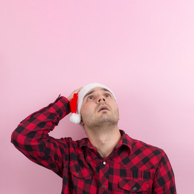 Foto emoções no rosto, medo, lembranças de férias, negativos. um homem em um coelho xadrez e um chapéu vermelho de natal