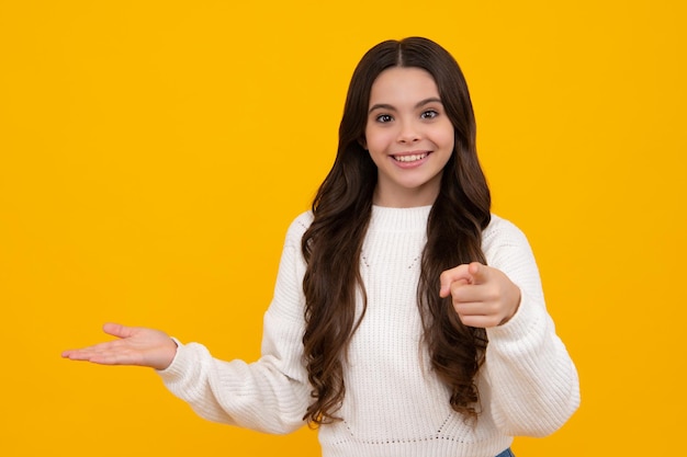 Emoções positivas e sorridentes de rosto feliz de menina adolescente Closeup retrato dela, linda, atraente, alegre, espantada, apontando de lado no espaço da cópia isolado no fundo amarelo