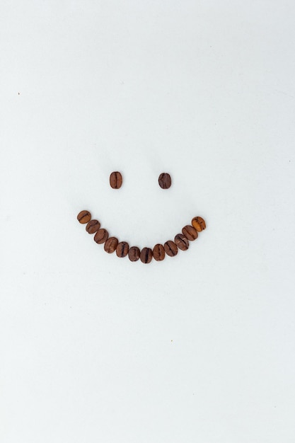 Emoji aus Kaffeebohnen auf weißem Hintergrund