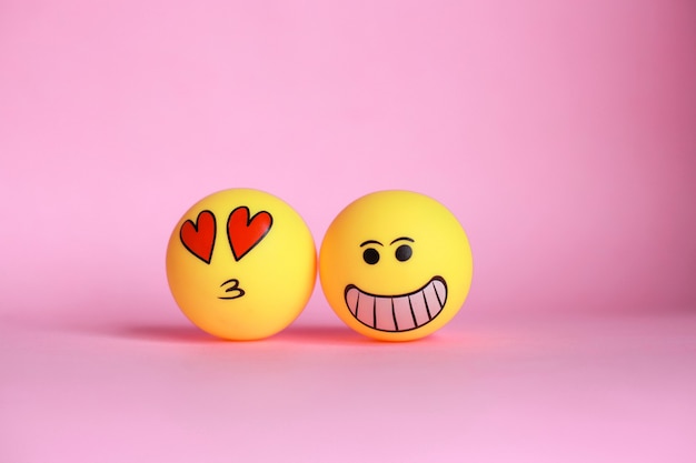 Foto emoticon sonriente y amor con besos en la boca sobre fondo rosa