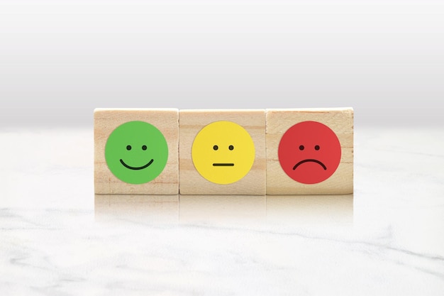 Emoticonos en bloques de madera Reseñas comerciales y concepto de satisfacción del cliente