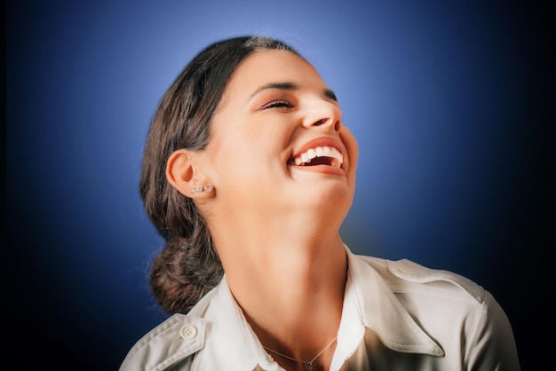Emotion Lachendes Gesicht einer schönen jungen Frau, die Studioportrait blauen Hintergrund lacht