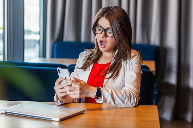 Emotionale Arbeiterfrau, die im Büro sitzt