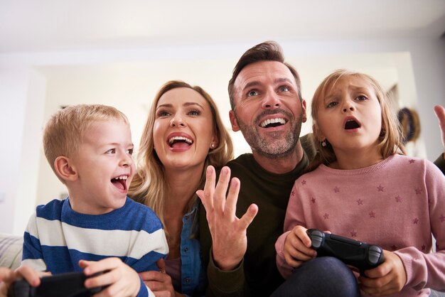 Emotionale Eltern und Kinder, die zu Hause Videospiele spielen