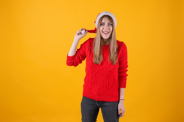 Emotionale Frau, die Sankt-Hut und rote Strickjacke trägt