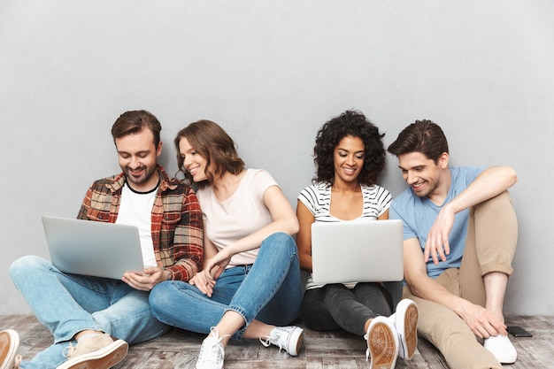 Emotionale Gruppe von Freunden mit Laptops.