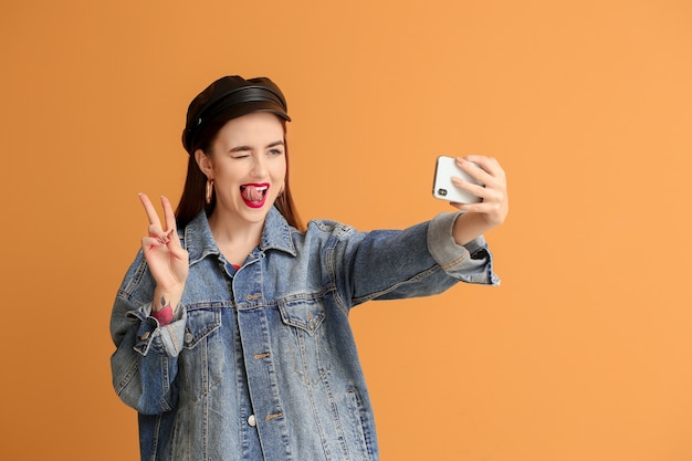 Emotionale junge Frau, die Selfie auf Orange macht taking