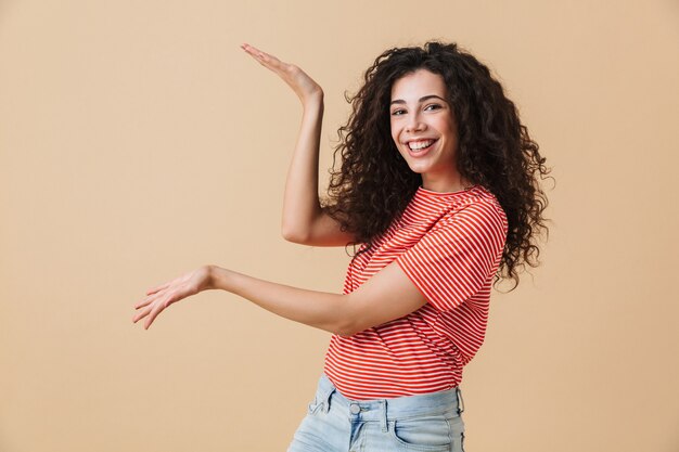 Emotionale junge Frau lokalisiert über beige Wand