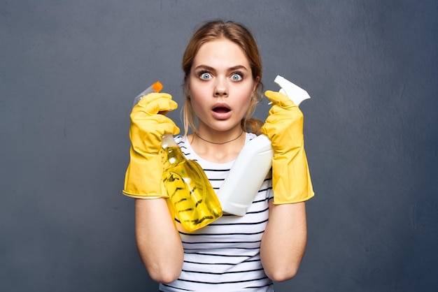 Foto emotionale putzfrau trägt gelbe gummihandschuhe mit waschmittelgrauem hintergrund hochwertiges foto