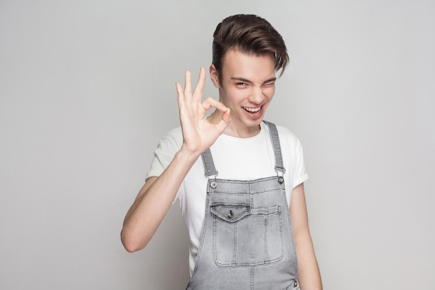 Emotionaler junger Mann auf grauem Hintergrund