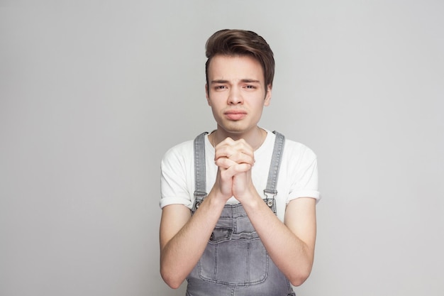 Emotionaler junger Mann auf grauem Hintergrund