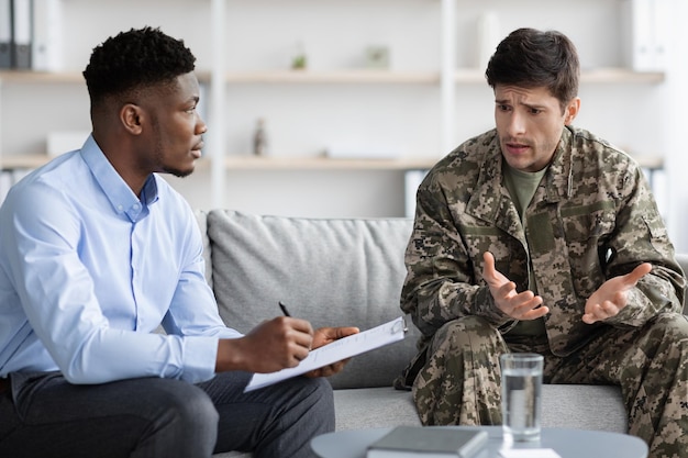 Emotionaler Soldat gestikuliert, während er mit Psychotherapeuten spricht