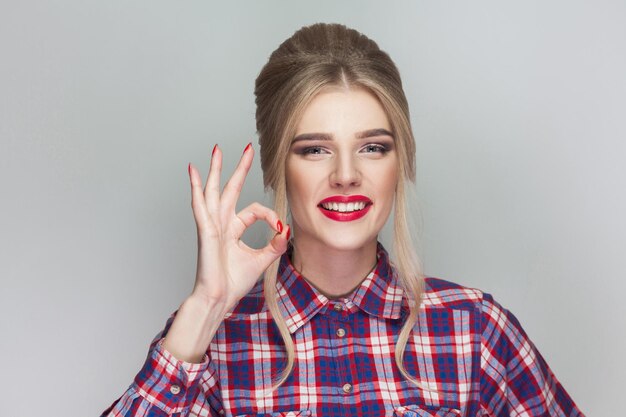 Emotionales blondes Mädchen auf grauem Hintergrund