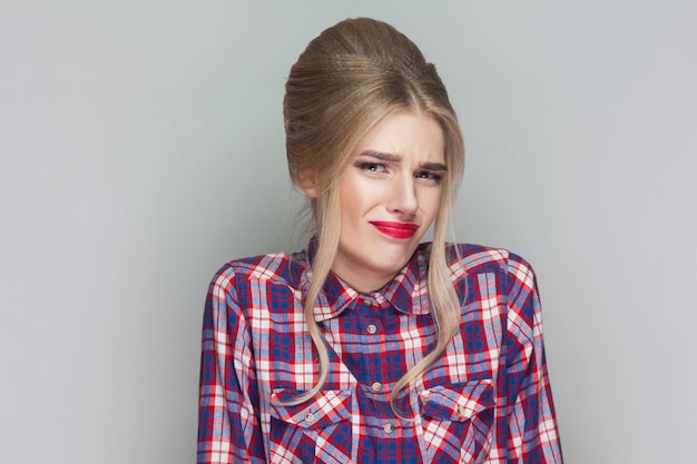 Emotionales blondes Mädchen auf grauem Hintergrund