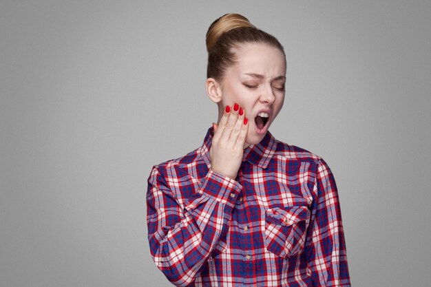 Foto emotionales blondes mädchen auf grauem hintergrund