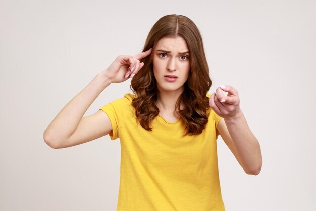 Emotionales junges Mädchen auf grauem Hintergrund