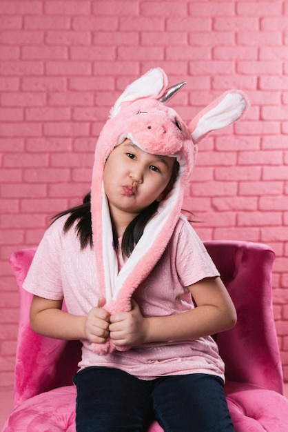 emotionales porträt eines asiatischen mädchens in halloween-kostümen auf rosa hintergrund