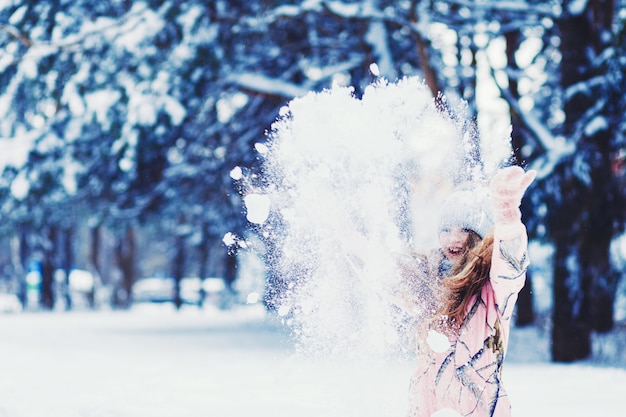 Emotionales Porträt eines kleinen Mädchens wirft Schnee