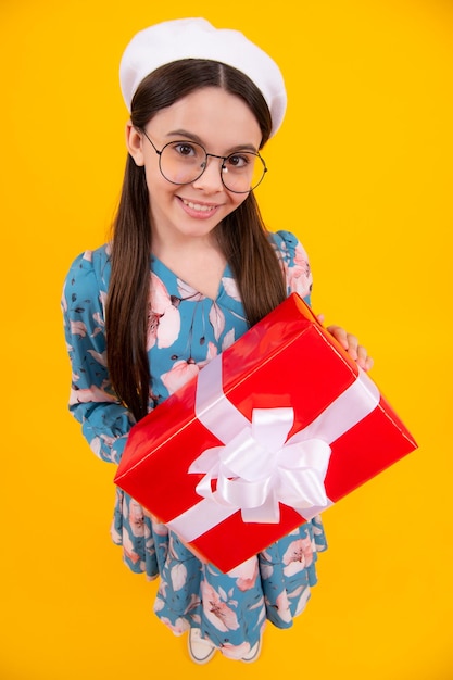 Emotionales Teenager-Kind hält Geschenk zum Geburtstag Lustiges Mädchen mit Geschenkboxen, das frohes neues Jahr oder Weihnachten feiert Fröhlicher Teenager positive und lächelnde Emotionen