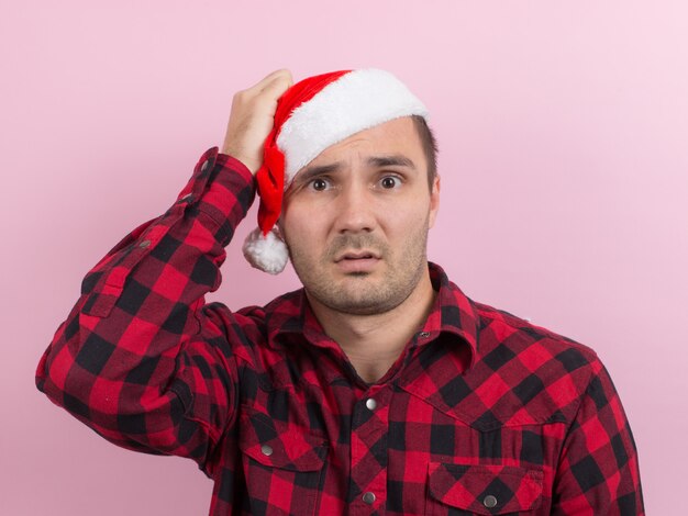 Foto emotionen im gesicht, angst, urlaubserinnerungen, negativ. ein mann in einem karierten kaninchen und einem weihnachtlichen roten hut