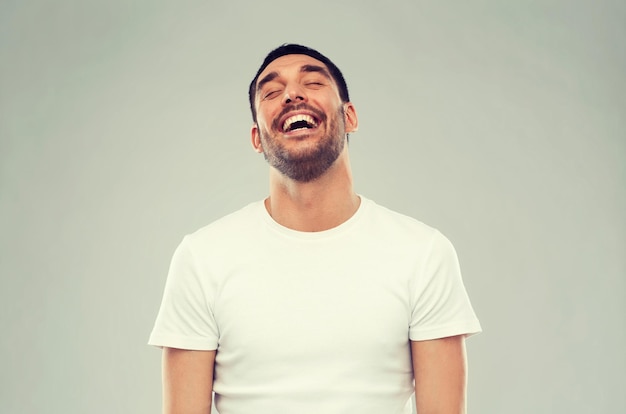 Emotions- und Personenkonzept - lachender Mann auf grauem Hintergrund