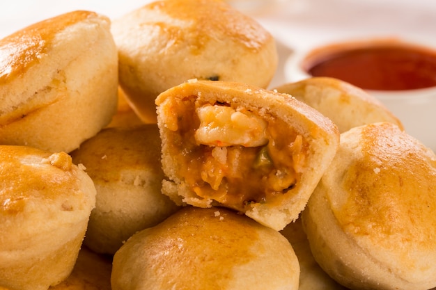 Empada lanche brasileiro. torta com camarão na chapa branca sobre fundo de madeira