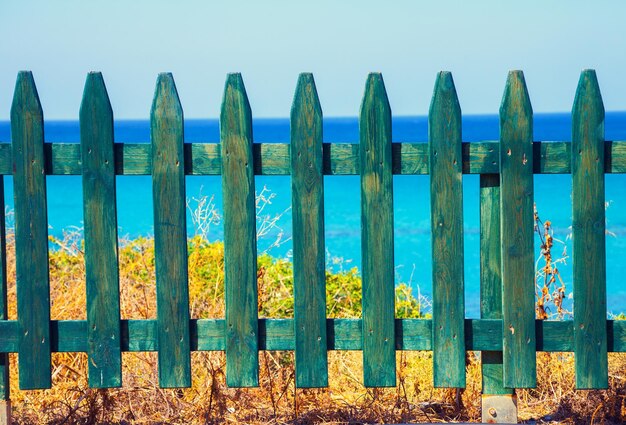 Foto empalidecendo de madeira na praia contra o mar