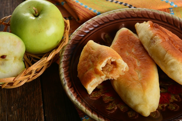 Empanada caliente con manzanas verdes frescas sobre fondo de madera