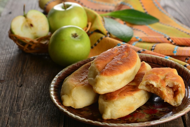 Empanada caliente con manzanas verdes frescas sobre fondo de madera