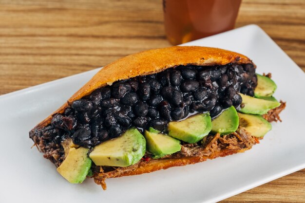 Empanada frita feita com carne de mechad, abacate e feijão preto, comida venezuelana