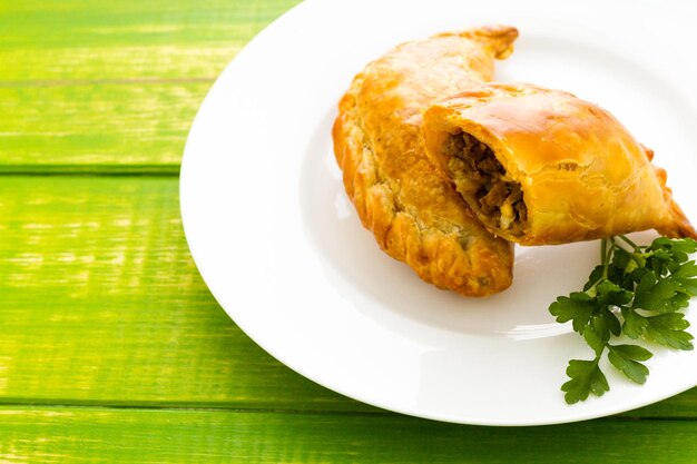 Empanada gefüllt mit Brot auf einem weißen Teller.