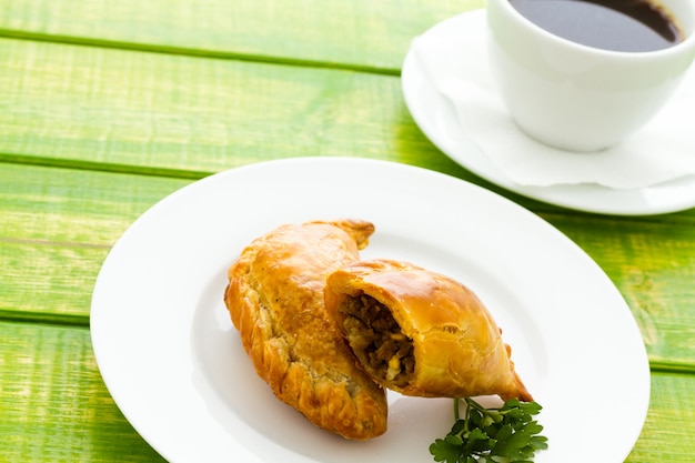 Empanada recheada com pão num prato branco.