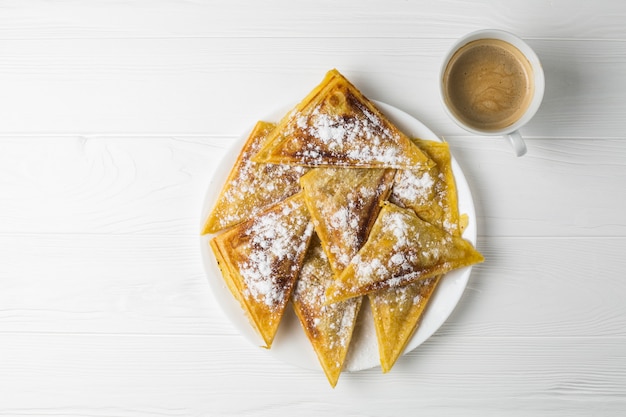 Empanadas caseras en un plato y una taza de café