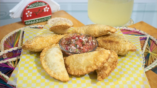 Empanadas con ají y limonada. Empanadas mixtas. Hogao picante. bandeja de pasabocas para reuniones