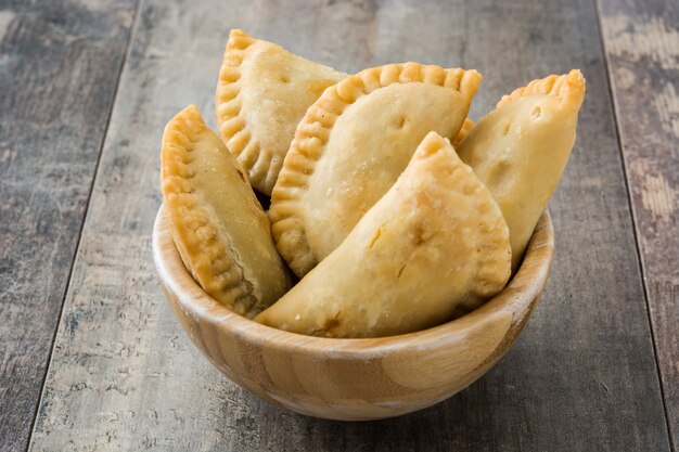 Empanadas espanholas típicas em tigela na mesa de madeira