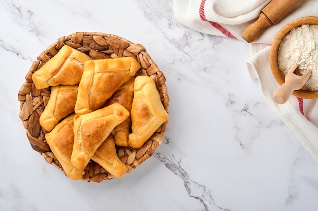 Empanadas fritas com coentro, carne, ovo, tomate e molho de pimenta no fundo branco. Conceito de dia da independência da América Latina e do Chile.