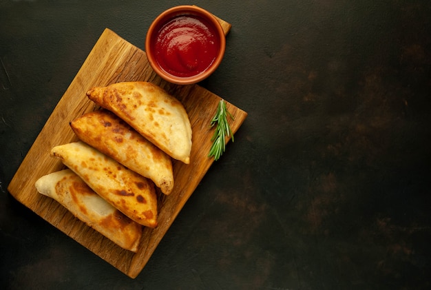 Empanadas fritas da América Latina com molho de tomate e espaço para seu texto de cópia