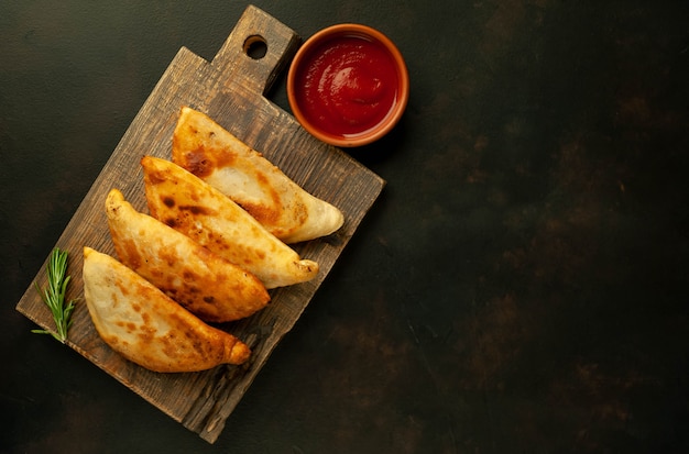 Empanadas fritas da América Latina com molho de tomate e espaço para seu texto de cópia