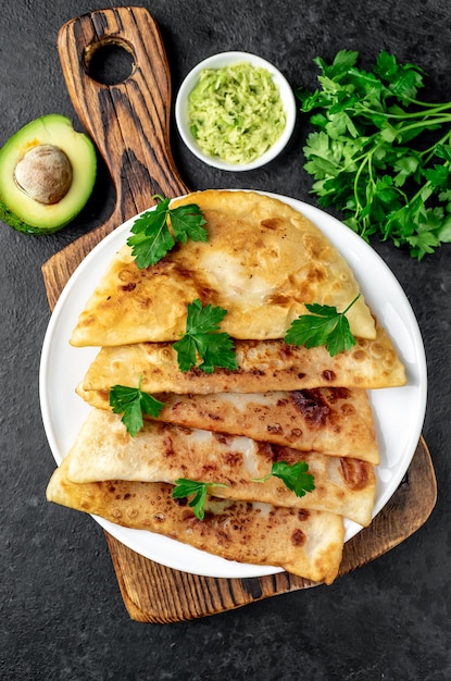 Empanadas fritas latinoamericanas con aguacate sobre una mesa de piedra