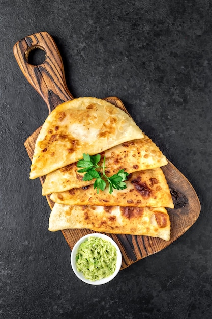 Empanadas fritas latinoamericanas con aguacate sobre una mesa de piedra