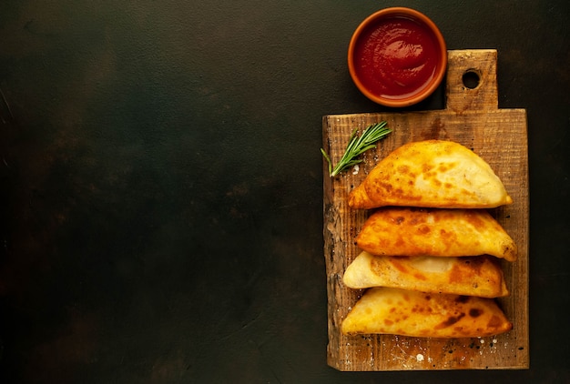 Empanadas latinoamericanas fritas con salsa de tomate con copia espacio para su texto