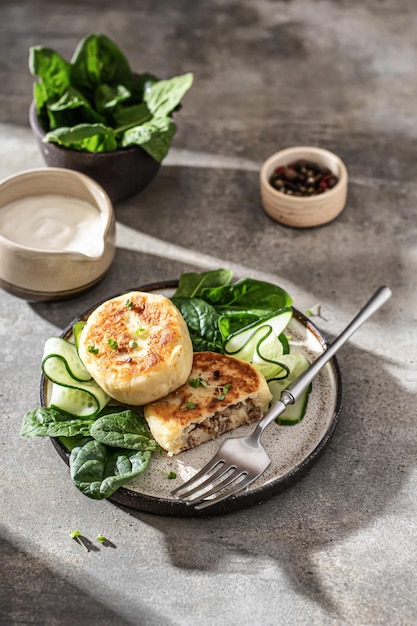 Empanadas de patata Rellenas de carne servidas con crema agria y verduras Comida tradicional ucraniana polaca bielorrusa Zrazy en alimentación moderna con sombras duras