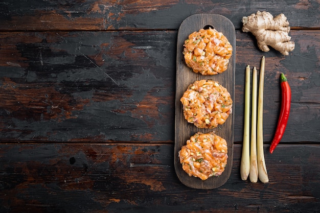 Empanadas de pescado crudo con filete de salmón y limoncillo, sobre la mesa de madera antigua, plano con espacio para texto